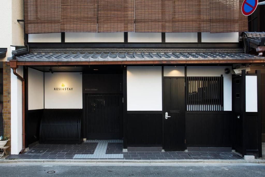 a building with black doors on a street at RESI STAY Fuyacho in Kyoto
