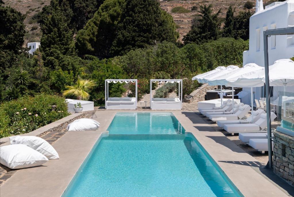 a swimming pool with lounge chairs and a swimming poolvisor at Chrysalis Nature Villa 9 in Kampos Paros