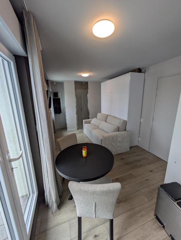 a living room with a table and chairs and a couch at Studio au coeur de Plouharnel in Plouharnel