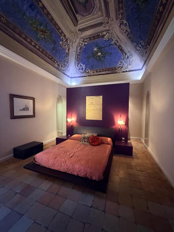 a bedroom with a bed with a blue ceiling at L' Appartamento Experience in Tivoli