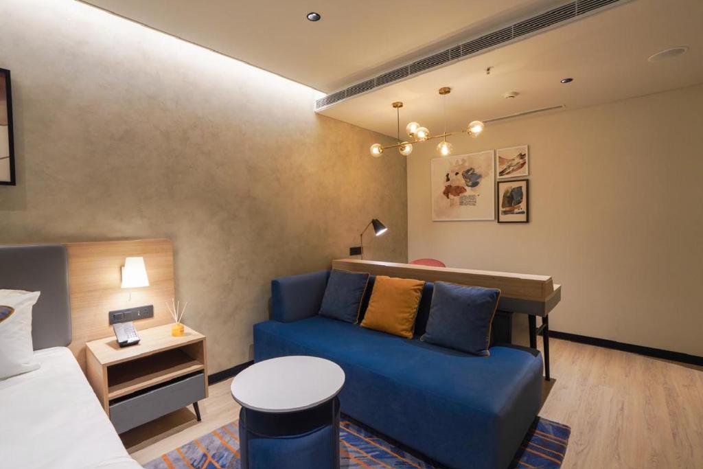 a living room with a blue couch and a desk at Orchid parc in Bangalore