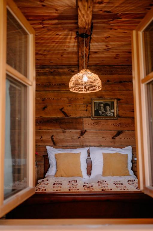 a bed in a room with a wooden wall at Smykowe Doły in Wilczyce