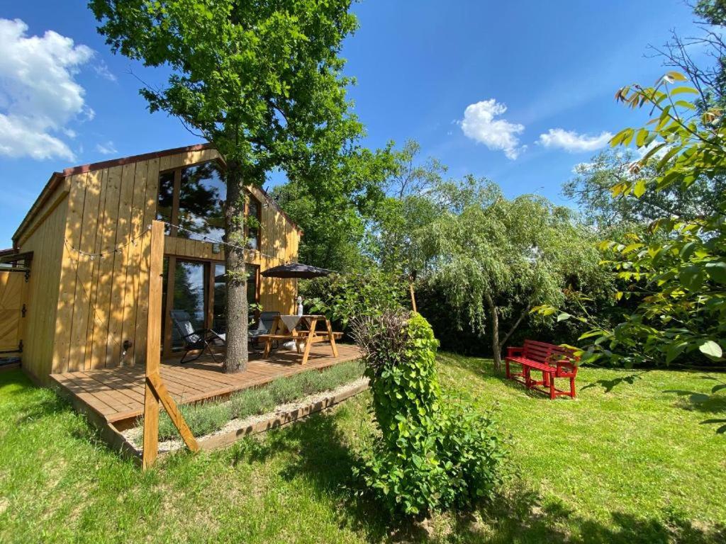 a small wooden cabin with a deck in the grass at Physio House Sokolik in Komarno