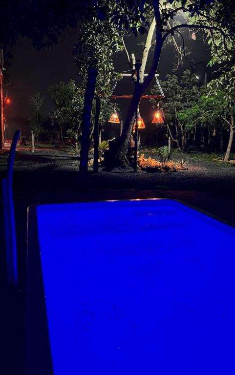 a blue light in front of a house at night at Chalés Crismel in Viçosa do Ceará