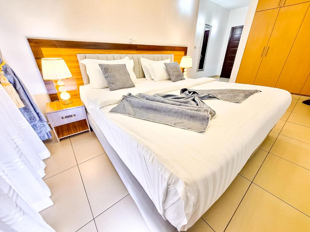 a bedroom with a large bed with a bag on it at LOUMIA Residency in Douala