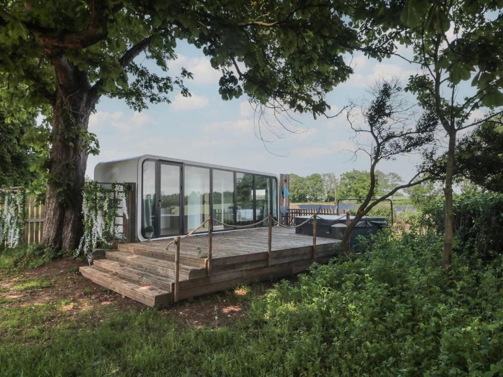 a house with a wooden deck and glass walls at Countryside Pod Retreat in Durston