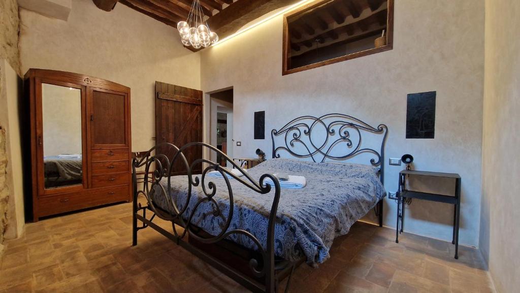 a bedroom with a black bed with a blue comforter at Domus Calzolari in Gubbio