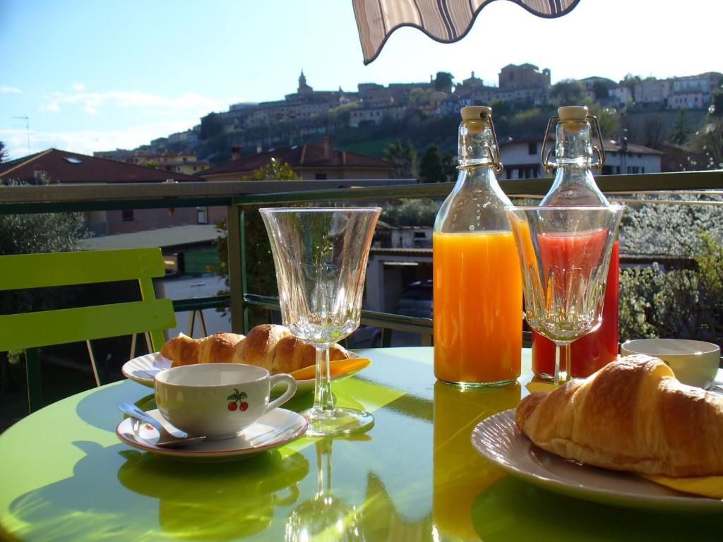 a table with two glasses of orange juice and croissants at B&B L'Incancellata in Corinaldo