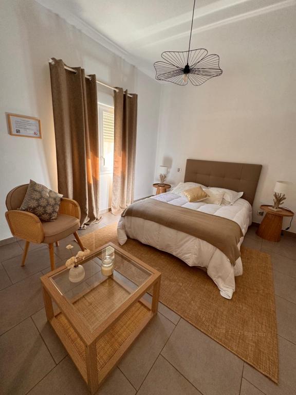a bedroom with a bed and a chair and a table at les chambres d'hotes du chalet in Venaco
