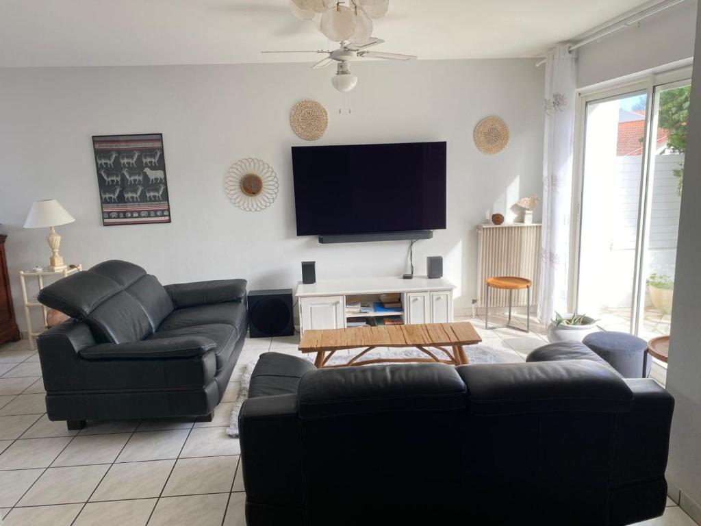 a living room with couches and a flat screen tv at maison Basque Maïana in Anglet