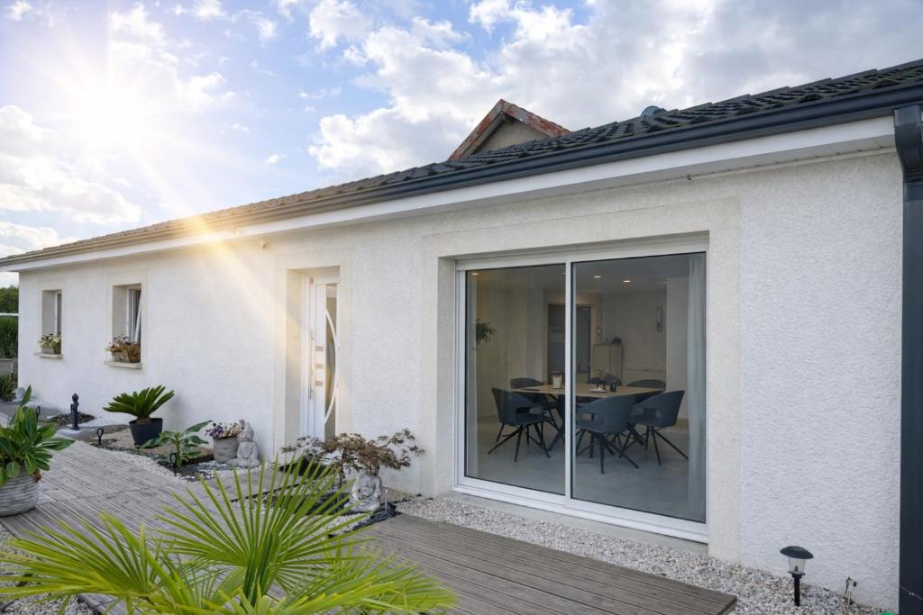 a house with sliding glass doors on a patio at Maison avec piscine in Golbey