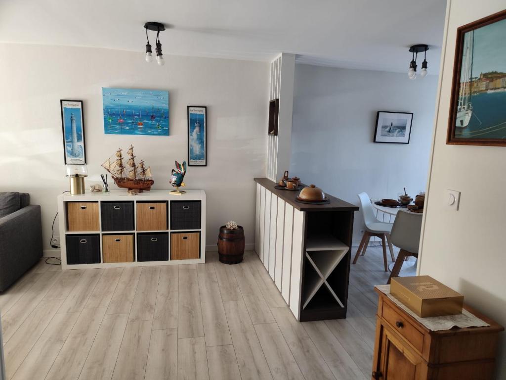 a living room with a table and a cabinet at Appartement paisible in Quévert