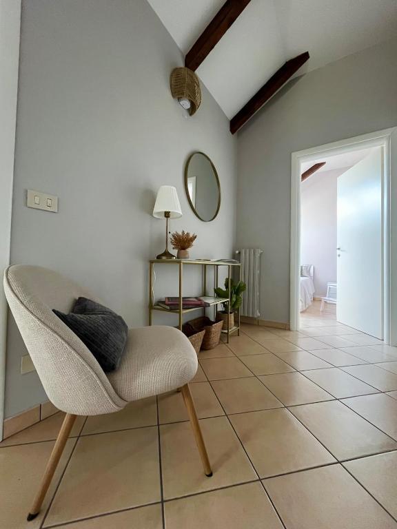 a living room with a chair and a mirror at Mokka Loft in Biella