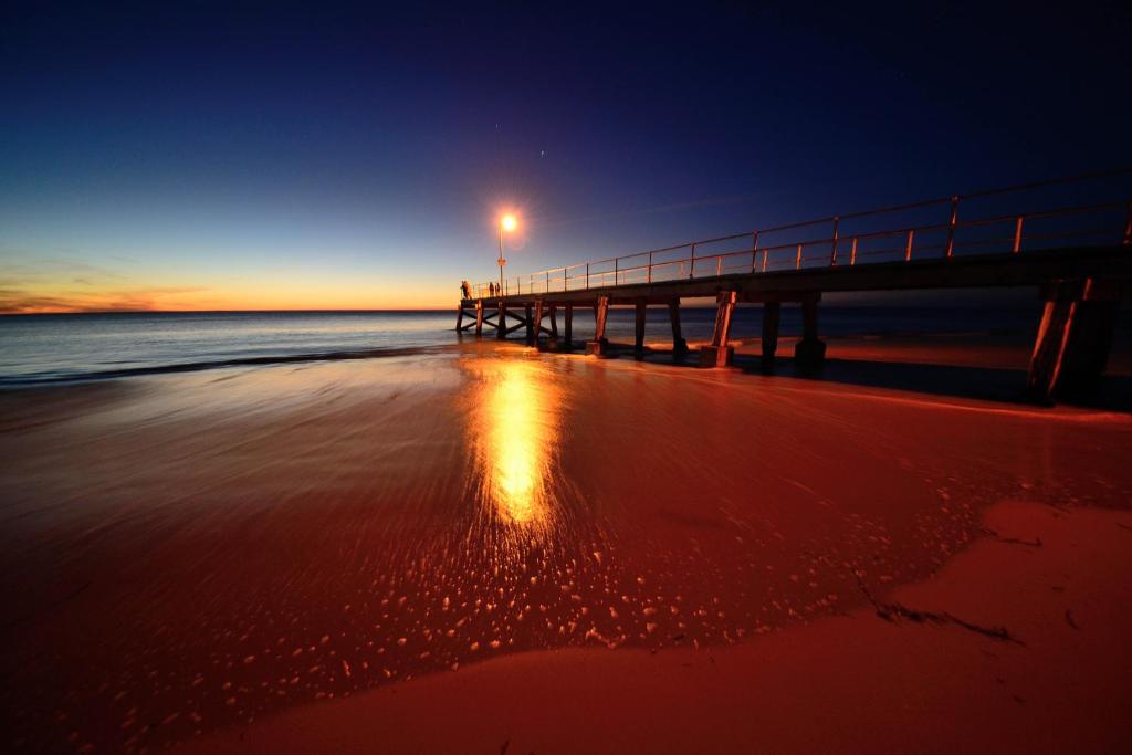 a pier with a light on the beach at night at Yankalilla Bay Homestead in Normanville