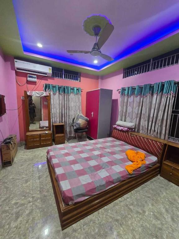 a bedroom with a large bed and a mirror at A Homestay in Amingaon