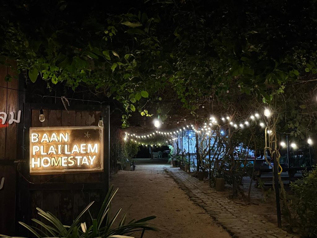 a sign for a hawaiian home stay at night at Baan Plai Laem resort Koh Paluay in Koh Phaluai