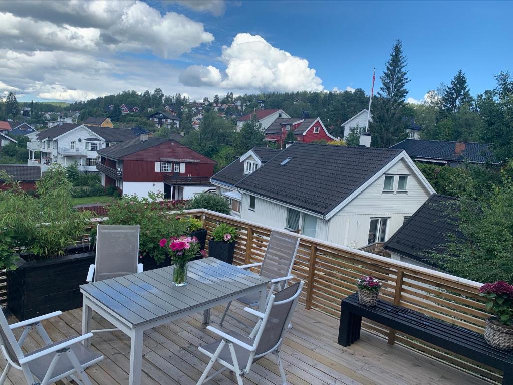 a wooden deck with a table and chairs on it at Modern 3BR Apartment Near Oslo Center Free Parking in Lorenskog