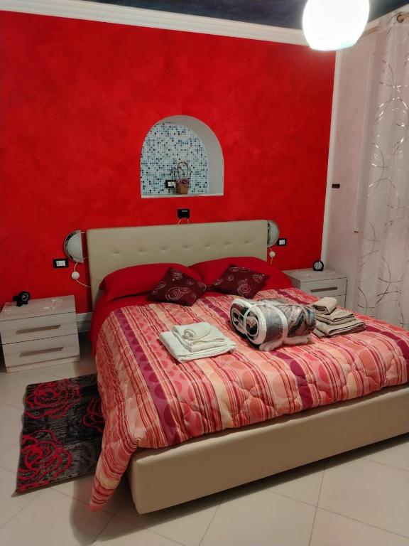 a bedroom with a bed with a red wall at Casa della Pace by Pinuccia in Roccaspinalveti