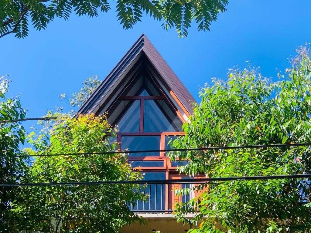 a building with a triangular roof with trees at Skyline Haven Ella Cabana in Ella