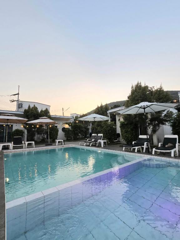 a large swimming pool with chairs and umbrellas at Aona Resort Kohlarn in Ko Larn