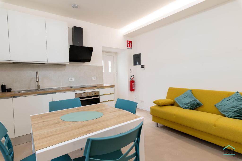a living room with a yellow couch and a table at Vetera Boutique by IXIHOME in Varese