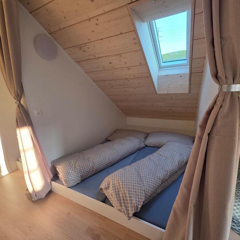 a small bedroom with two beds in a attic at Einzigartige Schlafkojen in Herisau