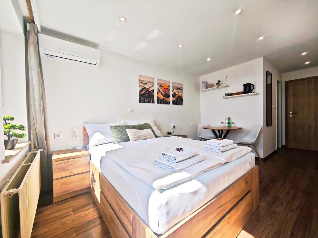 a bedroom with a large bed with white sheets at PAVLIN Bed & Breakfast in Šenturska Gora
