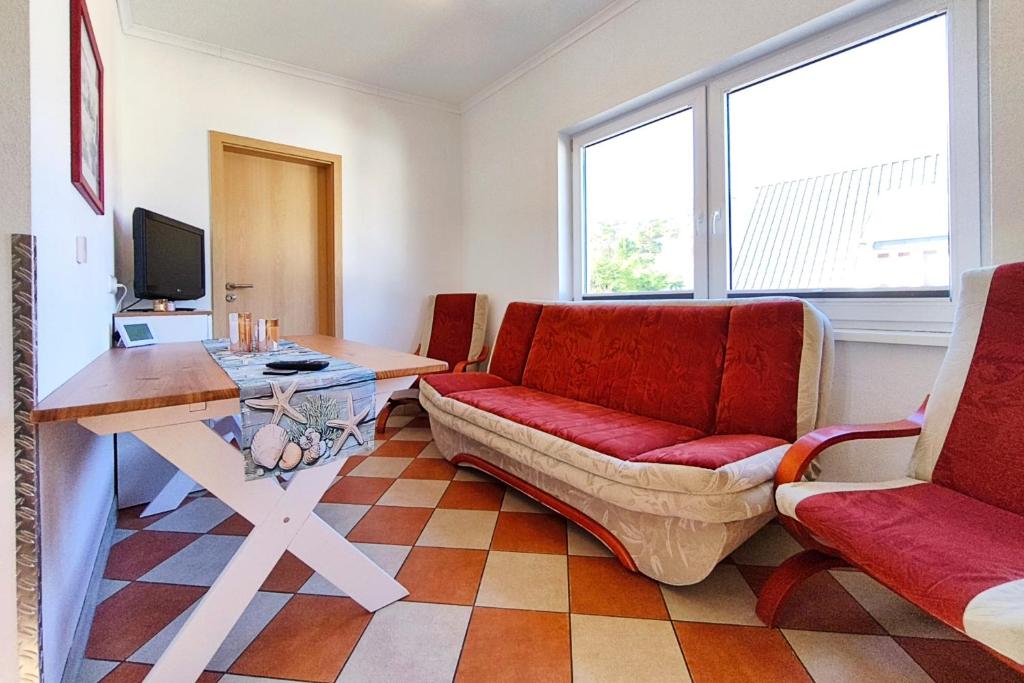 a living room with a couch and a table at Ferienwohnung Sonnenschein in Loddin