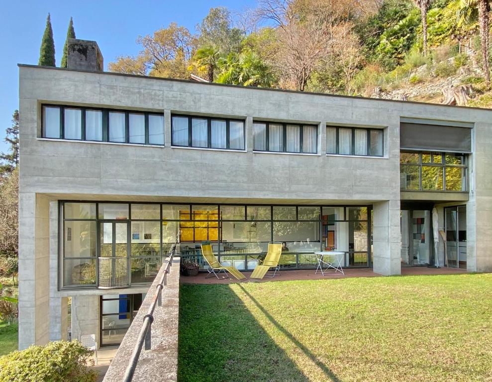a house with large windows and a yard at Villa Cavalli in Verscio