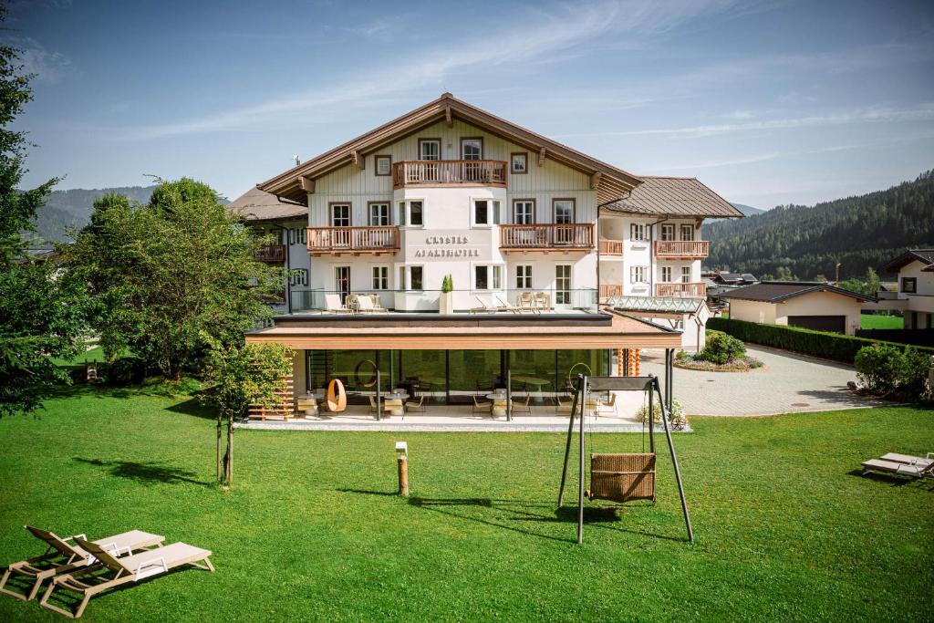 a large building with a lawn in front of it at Crystls Aparthotel in Flachau