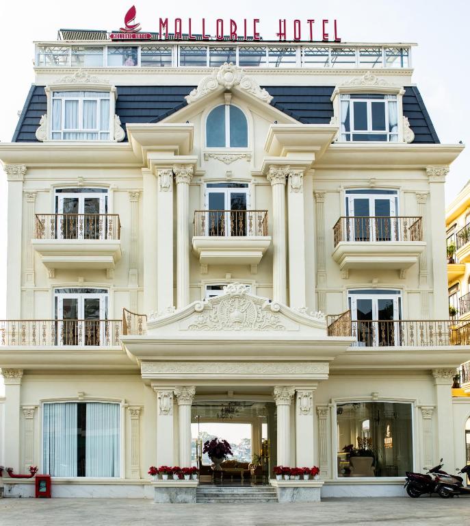a large white building with a sign on it at Mallorie Hotel Dalat in Xuan An