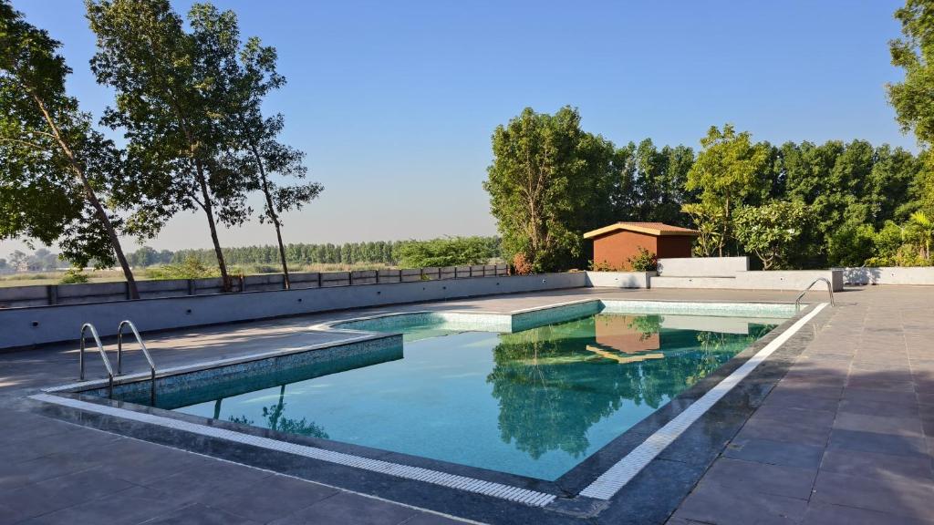 a swimming pool with blue water in a yard at Nal Village Resort By Explore With Nirav in Rupāwati