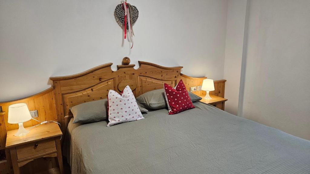a bedroom with a bed with pillows on it at Appartamenti Croz del Re 2 in Andalo