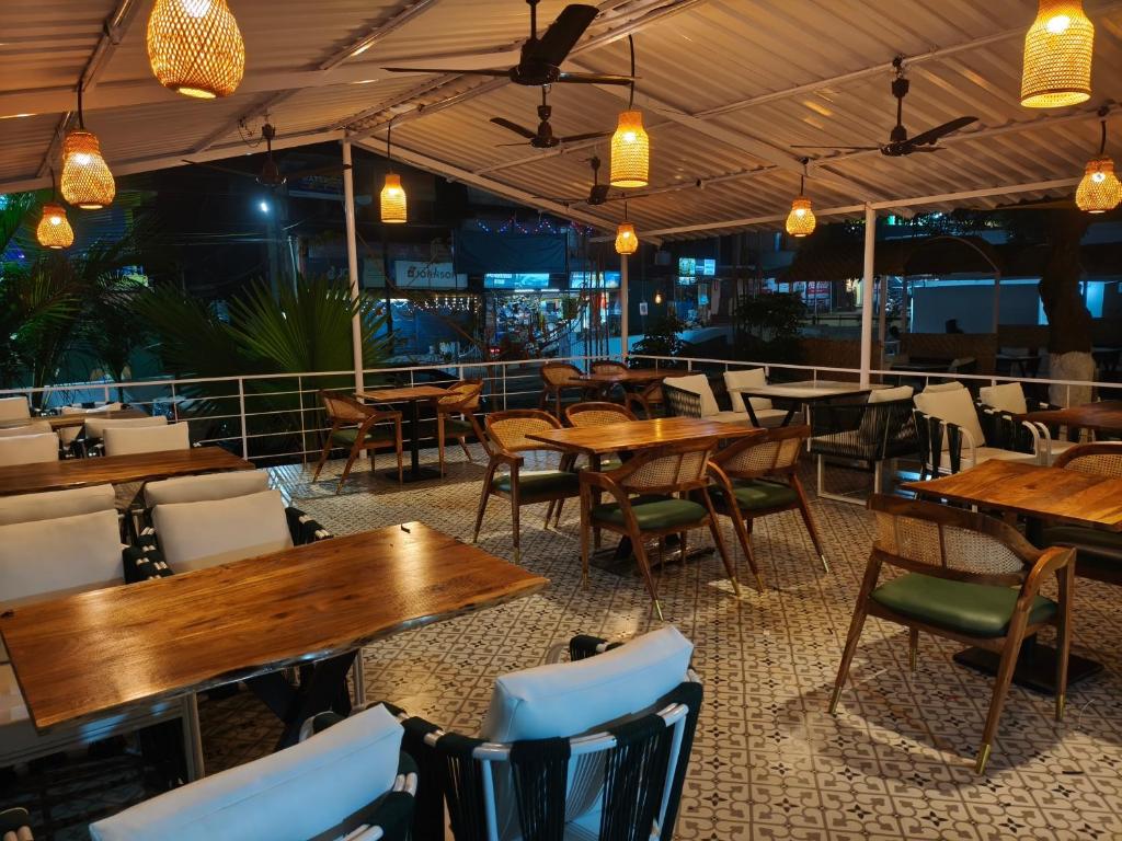 a restaurant with wooden tables and chairs and lights at Aurelia by Jackfruit in Arambol