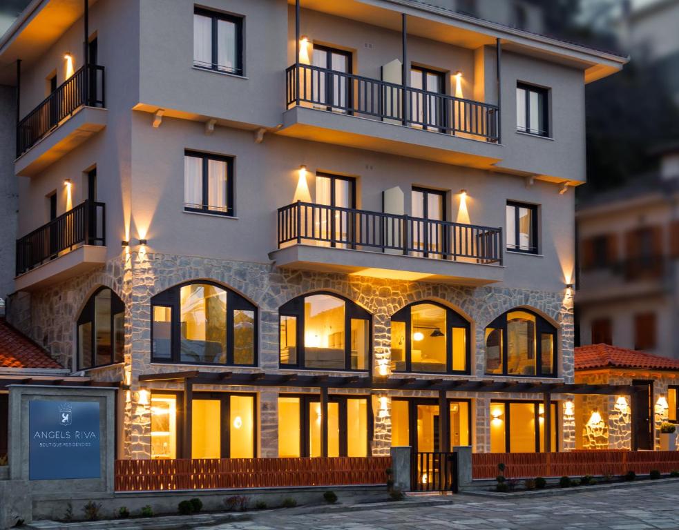 a large white building with windows and balconies at Angels Riva Boutique Residences in Kastoria