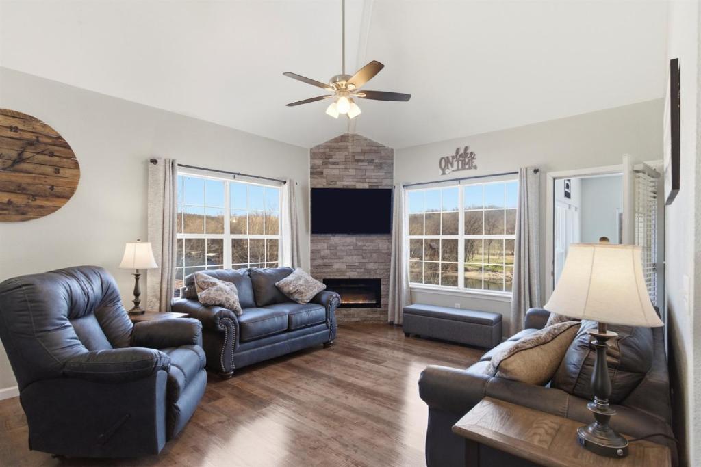 a living room with leather furniture and a ceiling fan at Waterfront Condo near Marina in Branson