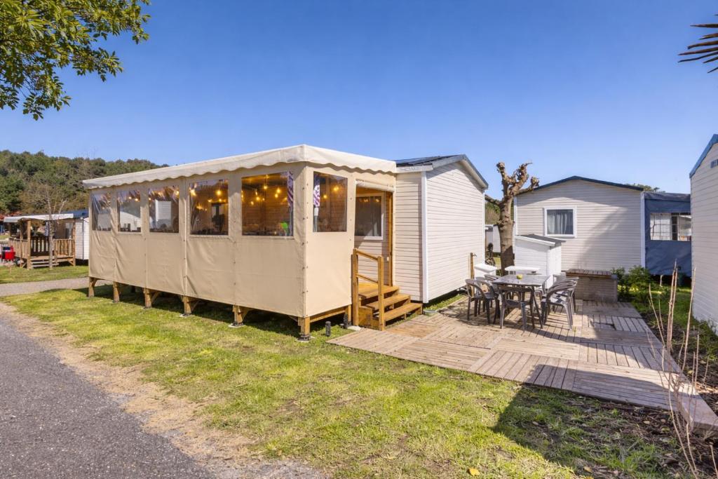 a tiny house in a yard with a patio at Mobilhome La Pause Océane - La Plage in Mimizan-Plage