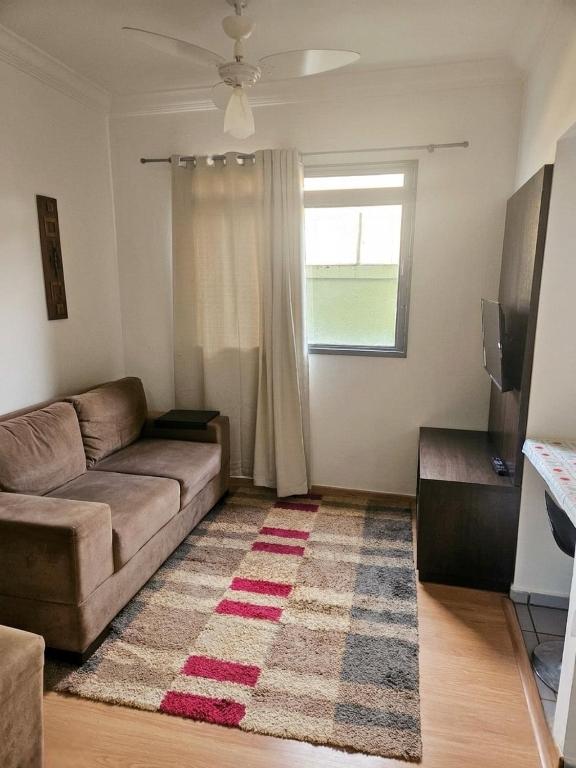 a living room with a couch and a window at Apto Completo com Conforto e Garagem Proximo a USP e HC in Ribeirão Preto