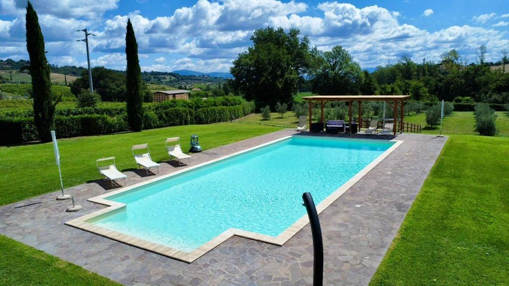 a swimming pool in a yard with chairs and a gazebo at Casale delle Querce in Orvieto