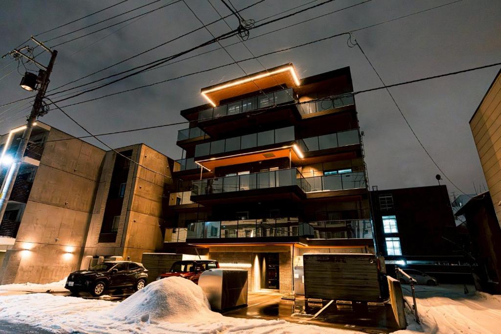a apartment building with snow in front of it at マエストラーレ山鼻 in Sapporo