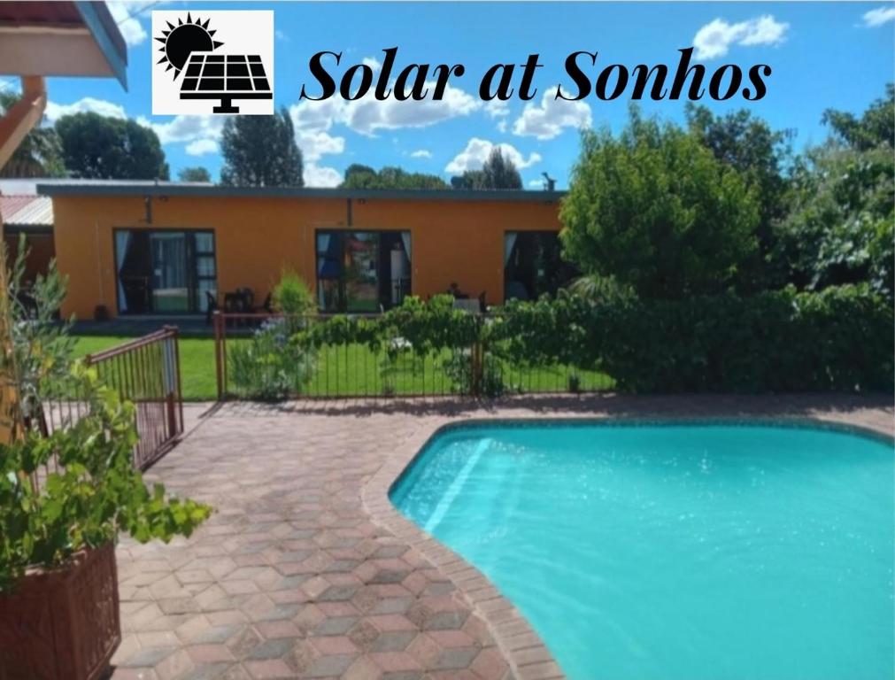 a swimming pool in front of a house at SONHOS dreams Self catering Garden Cottages in Bloemfontein