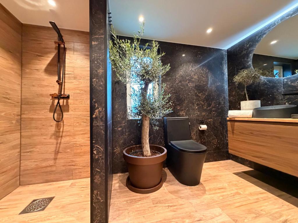 a bathroom with a shower and a toilet with plants at Vid Gekås Ullared Boende B&B in Ullared