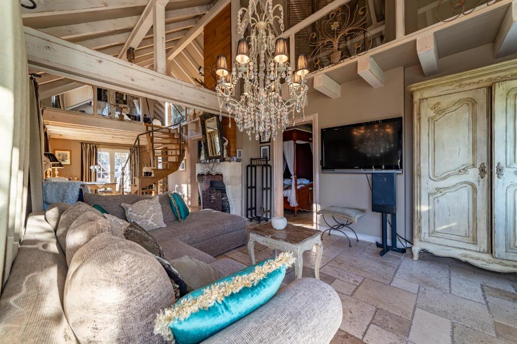a living room with a couch and a chandelier at Le B Cottage & SPA Privé in Riquewihr