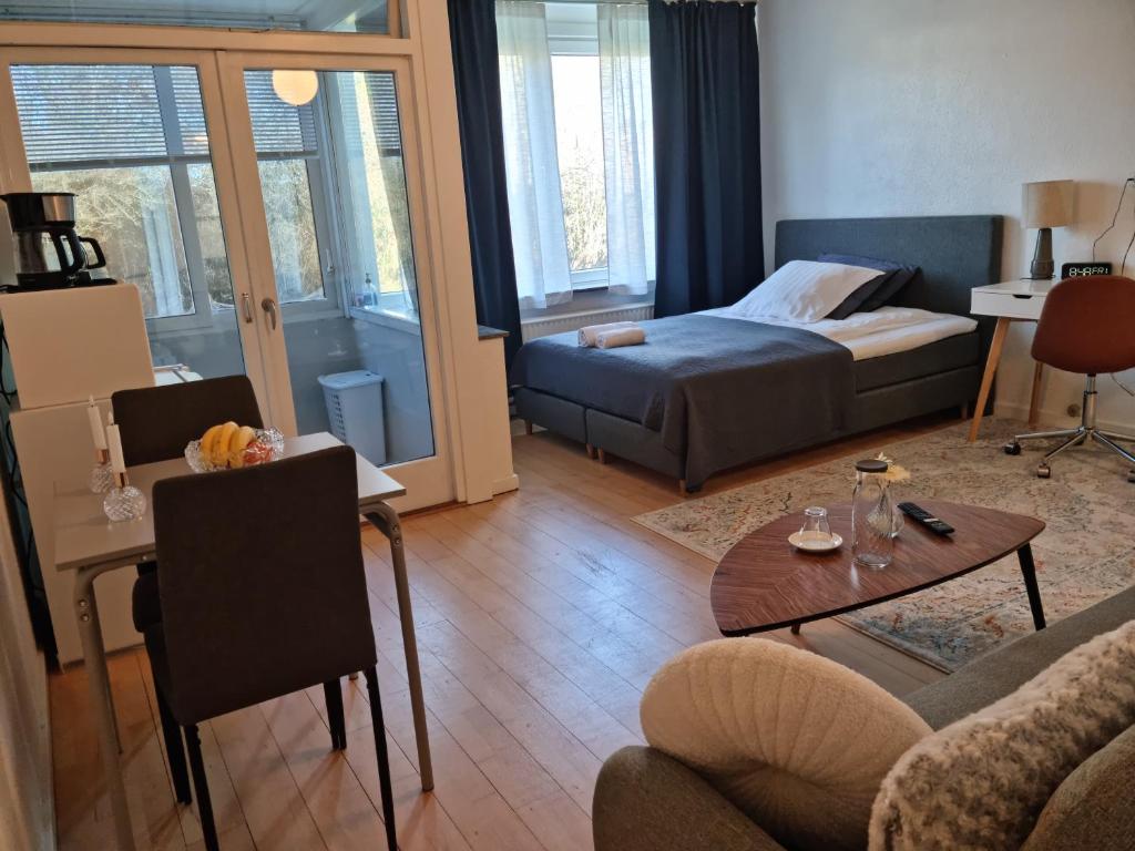 a living room with a bed and a table at Bayer Apartments Copenhagen in Rødovre
