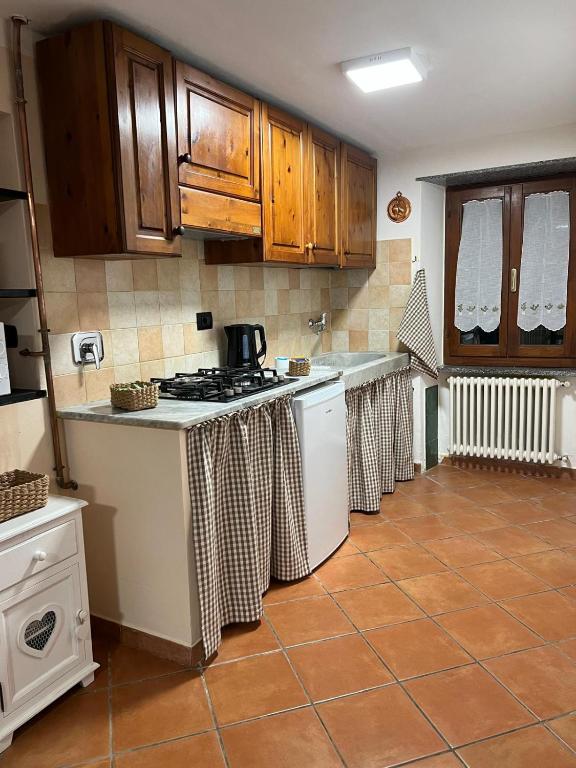 a kitchen with wooden cabinets and a stove top oven at Casa San Rocco in Busalla