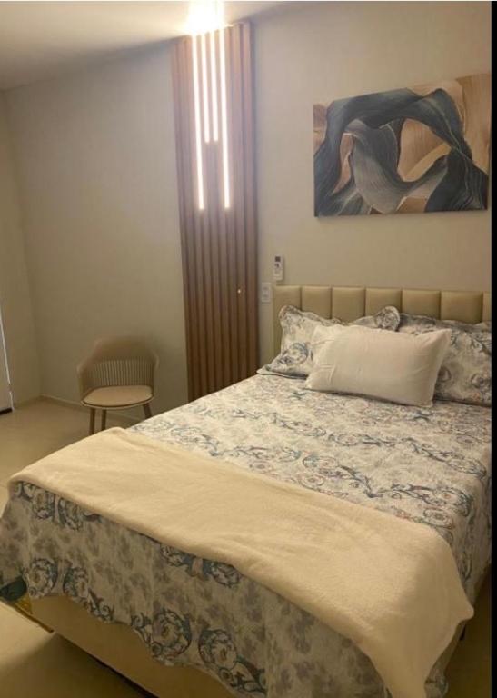 a bedroom with a bed with a painting on the wall at Pousada le sorelle in Rosário do Sul