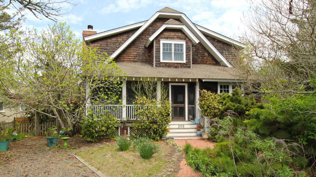 a brick house with a porch and a window at Cutest Cottage On Central in Cape May Point