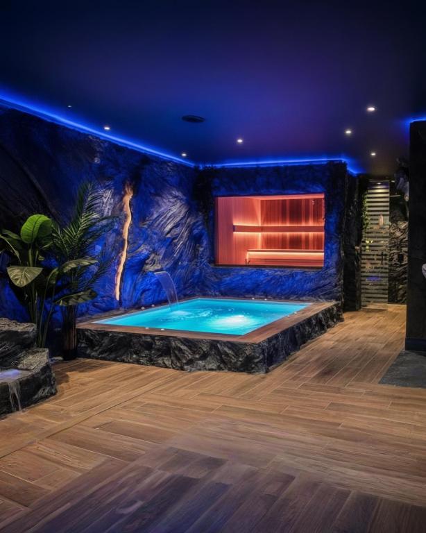 a swimming pool in a room with a blue wall at Casa Del G in Metókhi