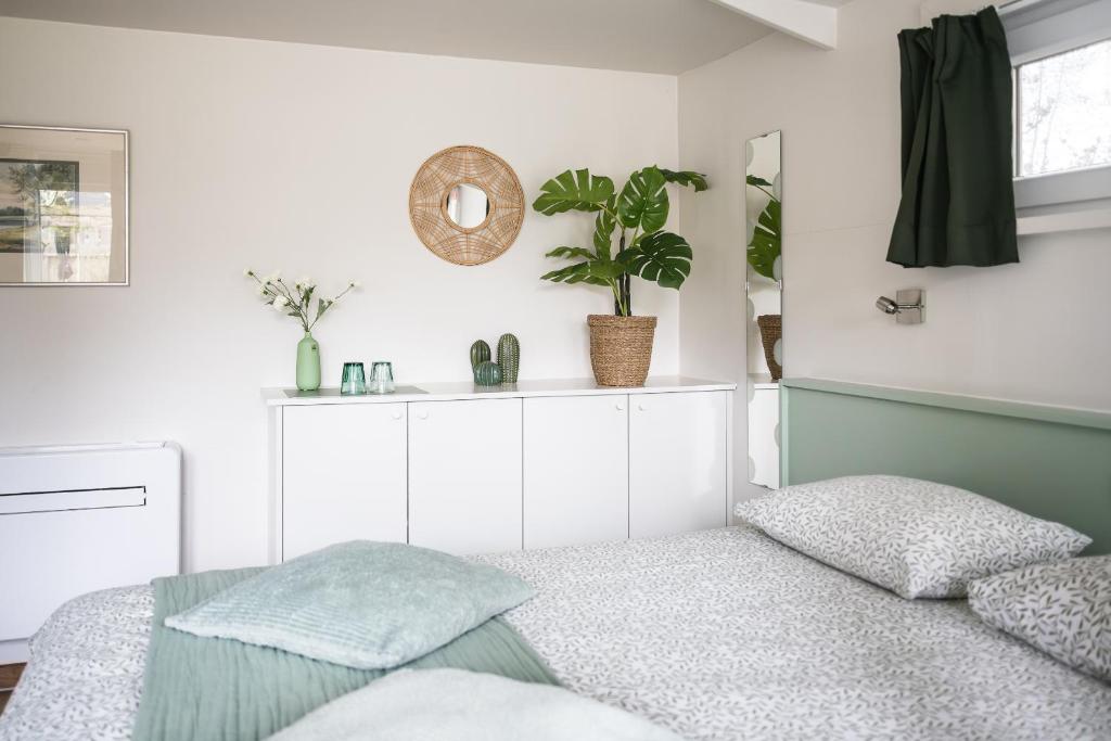 a white bedroom with a bed and a mirror at B&B Het Brembos in Wingene