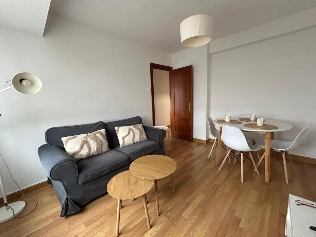 a living room with a couch and a table at La Costa Suite in Gijón